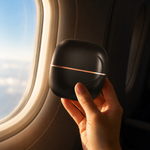 Pocket Bunny Mini Hair Brush it in a stylish black case held by a hand near an airplane window.